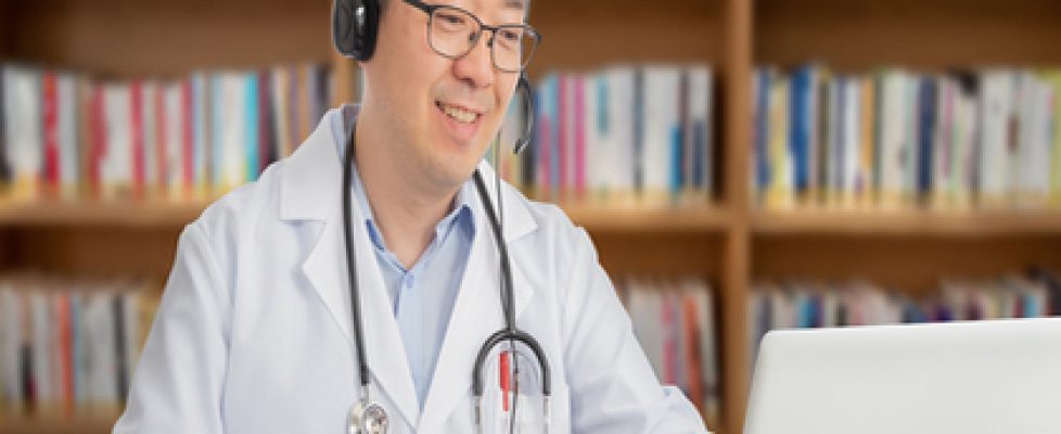 an Asian doctor who is remotely consulting with a patient. Telehealth concept