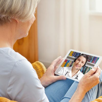 telemedicine concept, old woman with tablet pc during an online consultation with her doctor in her living room