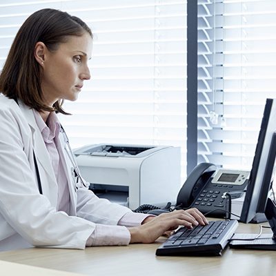 Female doctor working on computer at desk