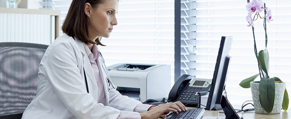 Female doctor working on computer at desk