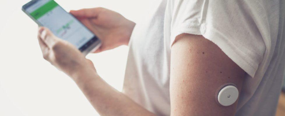 Woman,Checking,Glucose,Level,With,A,Remote,Sensor,And,Mobile