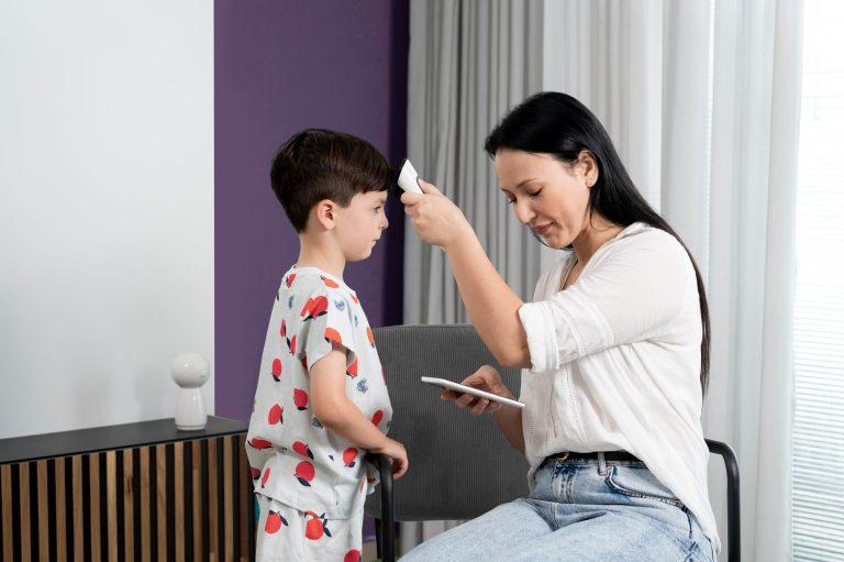 Parent helping a child use the N9+ for a guided temperature exam